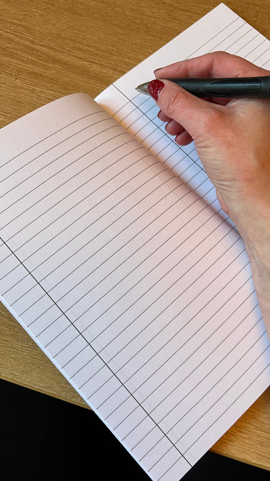Inside of a notebook with someone holding a pen about to write on the page