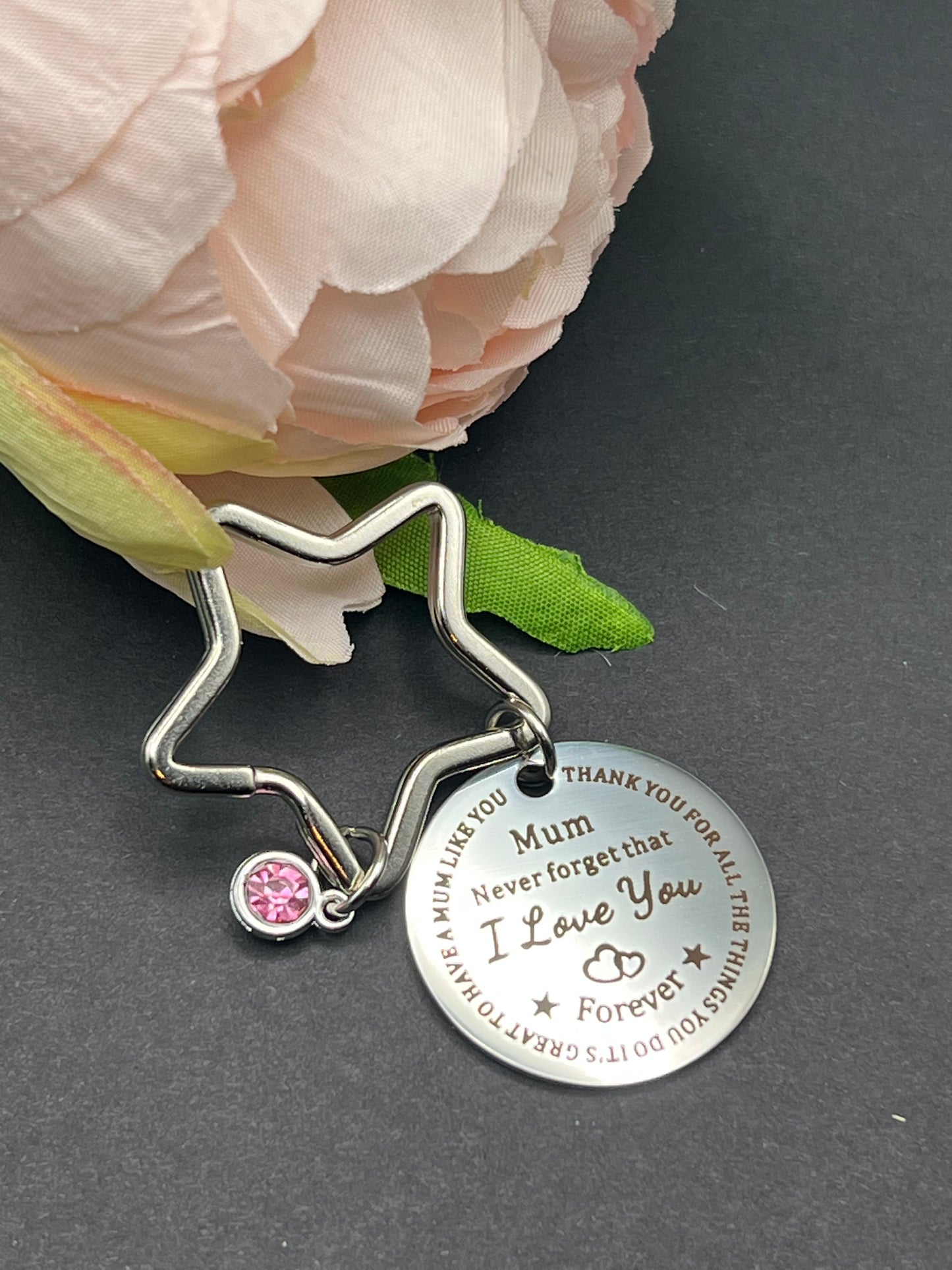 Star shaped key chain with a pink jewel charm and a circle tag charm with the words "Mum Never forget that I Love You Forever" inscribed in the middle.