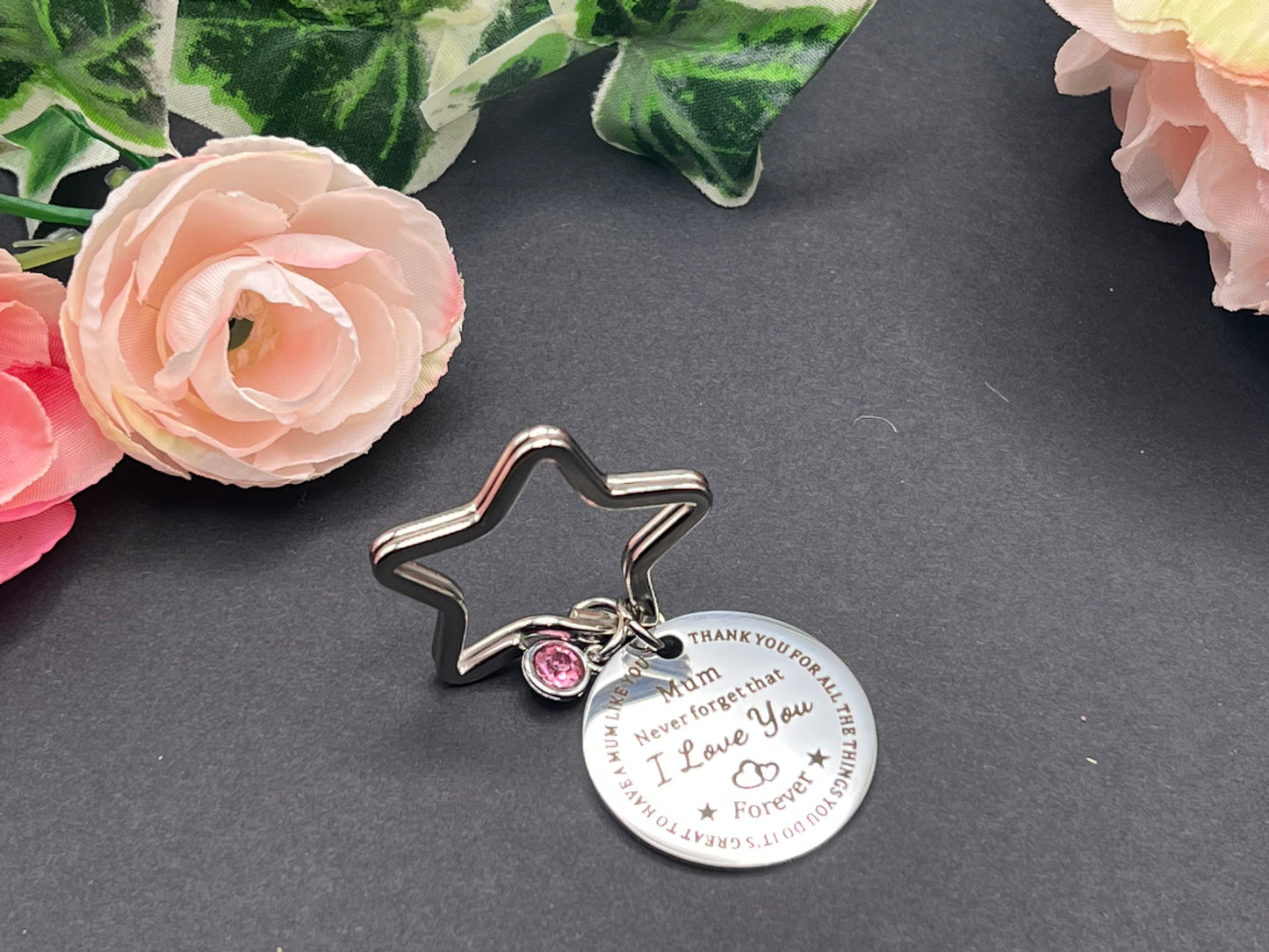 Star shaped key chain with a pink jewel charm and a circle tag charm with the words "Mum Never forget that I Love You Forever" inscribed in the middle.