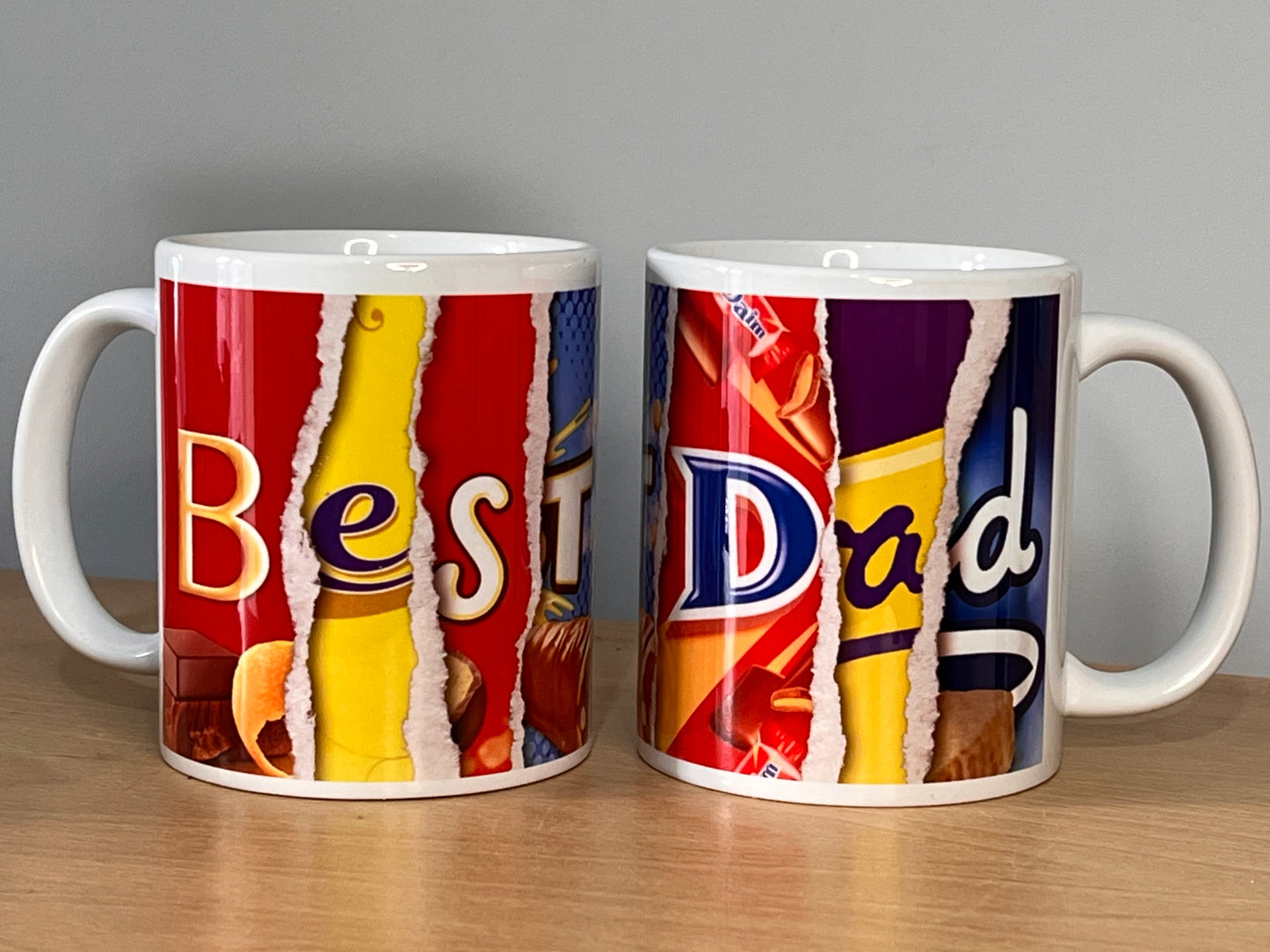 2 (two) mugs containing the words Best Dad which are formed using words from images from chocolate wrappers